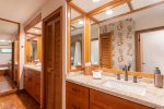 Vintage Maui orange clay tile floors and festive pineapple wallpaper adorn the master bathroom